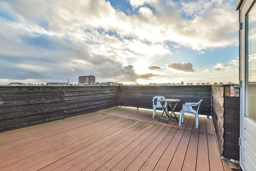 a rooftop deck with a table and chairs on it