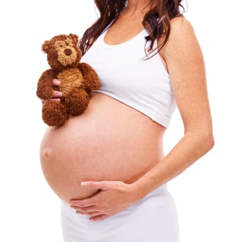 Ready for the new arrival. A pregnant mother holding a teddy bear against a white background.