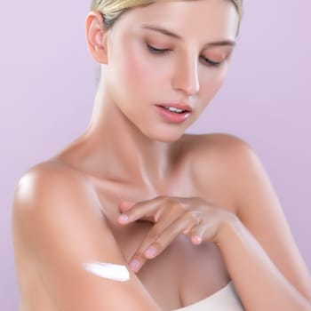 Closeup alluring beautiful woman applying moisturizer cream on her arm for perfect skincare treatment in isolated pink background. Caucasian women portrait with skin rejuvenation and cosmetic concept.