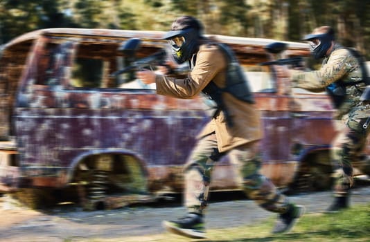 Paintball, team work or people running in shooting game with speed or fast action on a fun battlefield. Mission focus, blurry caravan or men with guns for survival in competition in nature or forest