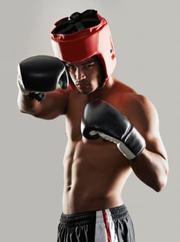 Hes dedicated to the sport of boxing. Portrait of a young male boxer in a fighting stance.