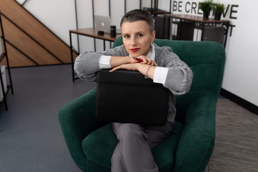 businesswoman sitting in a chair with a folder of her cases