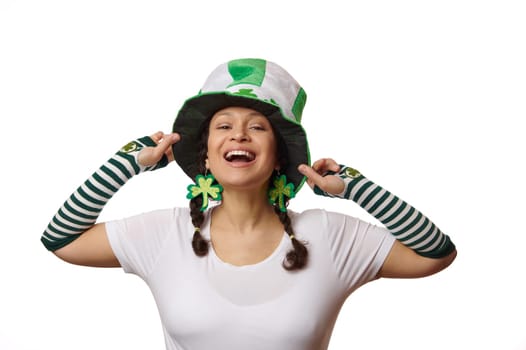 Portrait on white background of a pretty woman in Saint Patrick's hat, smiling with a beautiful smile looking at camera