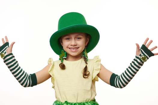 Charming Irish little girl in carnival costume, smiles looking at camera, isolated over white background. St Patrick Day