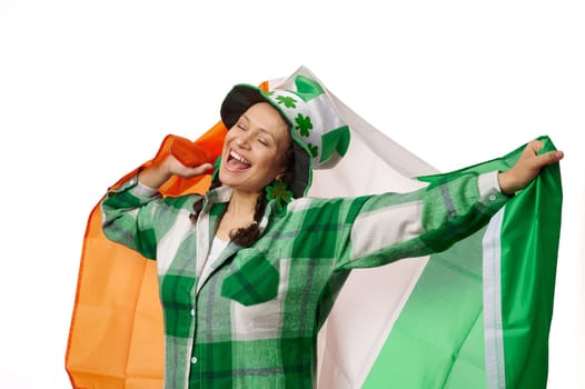 Happy woman carrying Irish flag, celebrating Saint Patrick's Day on isolated white background. Culture and traditions