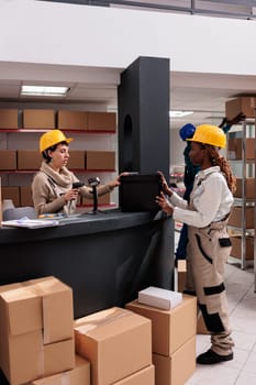 Warehouse manager scanning case at counter desk, doing inventory