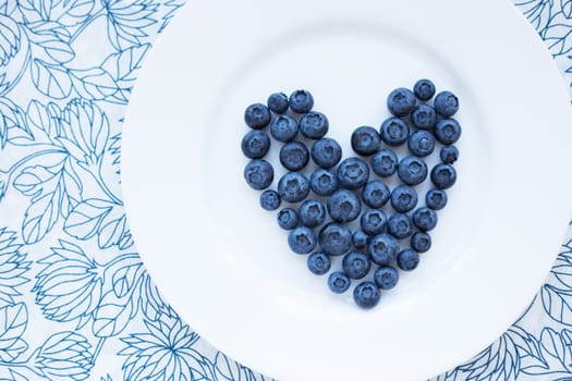 blueberries in a heart shape on a white plate