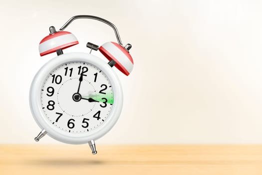 Time change in Austria, spring forward. Summer time concept, over white background. A white alarm clock with a minute hand indicates that the time has been moved forward an hour with copy space.