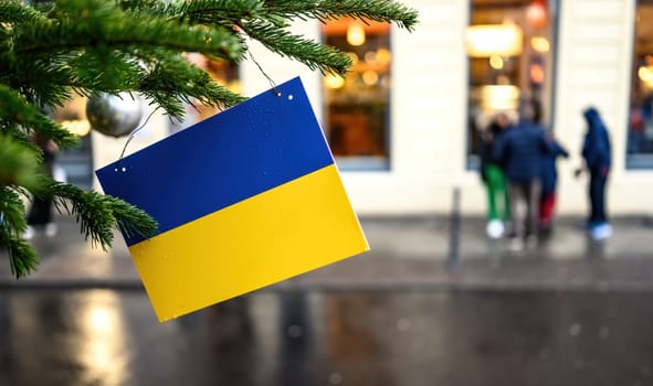 Ukrainian flag on a Christmas tree against city