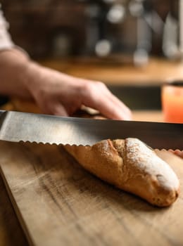 Girl hand cut french baguette with knife