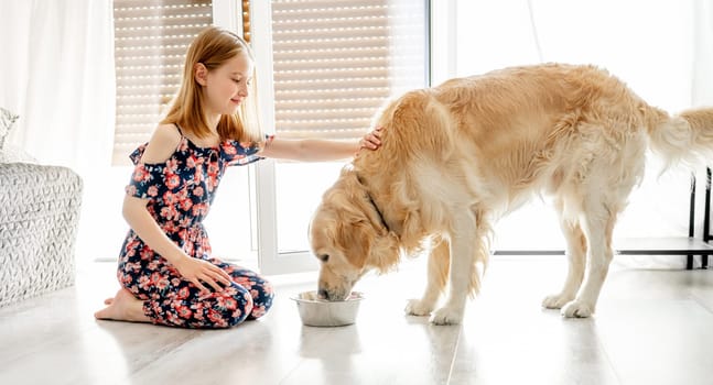 Golden retriever dog eating food with girl