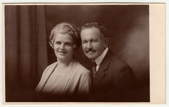 Vintage photo shows a mature couple. Black & white antique studio portrait. Sepia tone