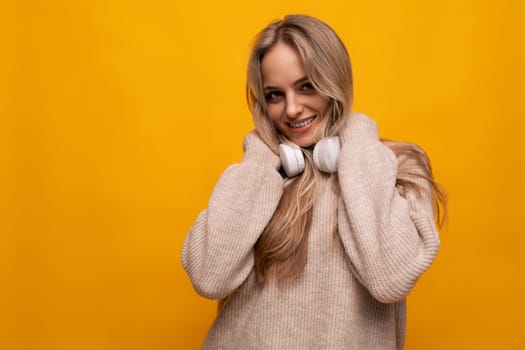girl with a grimace in headphones on a yellow background