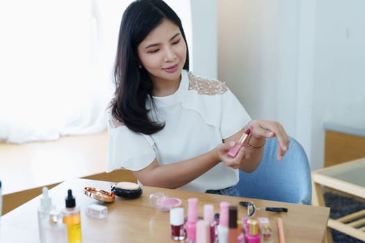 online trading business, a beautiful young woman working independently at home reviewing cosmetic products through the camera to customers to increase their interest in making a purchase decision