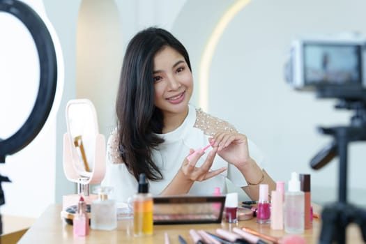 online trading business, a beautiful young woman working independently at home reviewing cosmetic products through the camera to customers to increase their interest in making a purchase decision