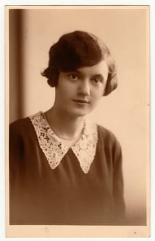 The vintage photo shows portrait of young woman. The studio photography with sepia effect was taken in early 1930s.