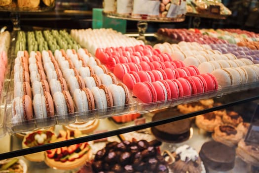 Macaroons cakes in confectionery shop. Colorful Italian sweets. Traditional food for breakfast