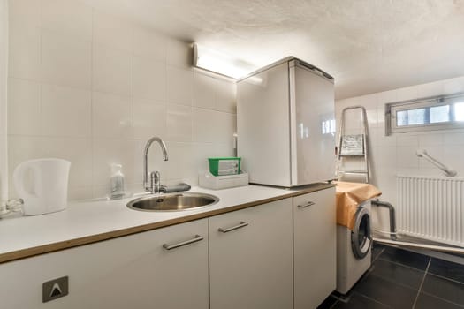 a white kitchen with a sink and a washing machine
