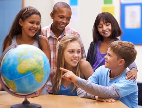 They share an interest for geography. A group of learners looking at a globe during geography class.