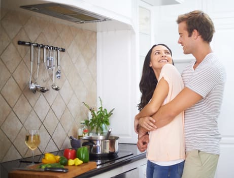 Food for the family. A young couple embracing each other in the kitchen.