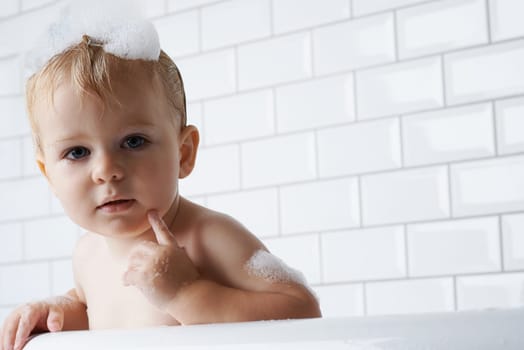 Waiting for mommy to wash me. Portrait of an adorable baby boy standing in the bath tub.