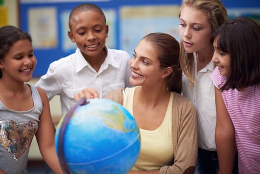 Its a big world. a teacher teaching her students about the globe in a classroom.