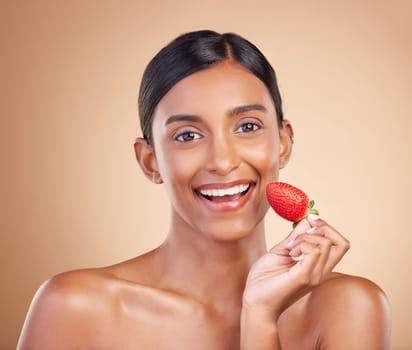 Portrait, skincare and strawberry with a model woman in studio on a beige background to promote beauty. Face, fruit and nutrition with an attractive female posing for organic or natural cosmetics