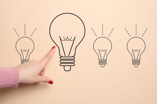 A drawn light bulb and a female hand pointing at it, concept of searching for new ideas, innovation