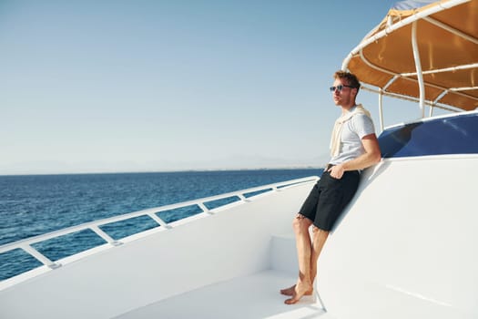 Young male tourist is on the yacht on the sea. Conception of vacation