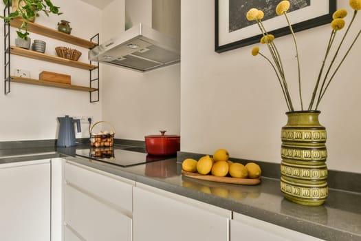 a kitchen counter with lemons and a vase