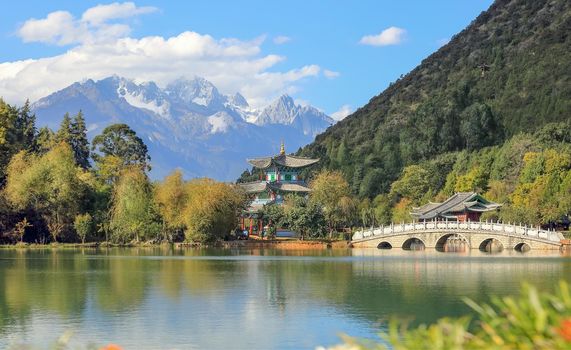 Jade Dragon Snow Mountain and the Suocui Bridge over the Black Dragon Pool in the Jade Spring Park, Lijiang, Yunnan province, China.