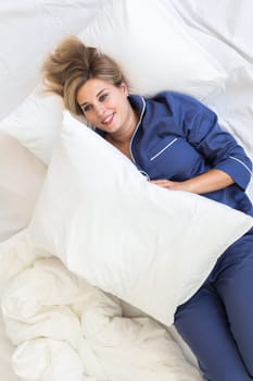 Cheerful woman lies in bed rest morning comfort - sleep time and relax