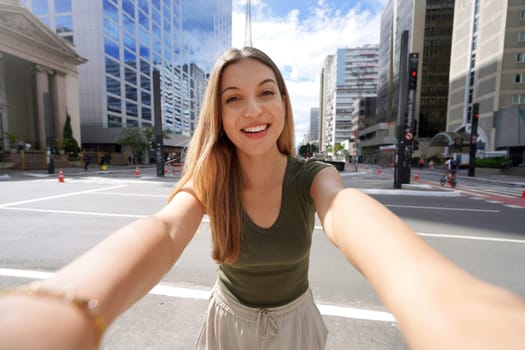 Self portrait of young beautiful Brazilian woman with modern casual style clothes on the Paulista Avenue, Sao Paulo, Brazil