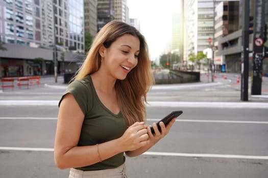 Attractive Brazilian woman using mobile phone on Paulista Avenue, Sao Paulo, Brazil