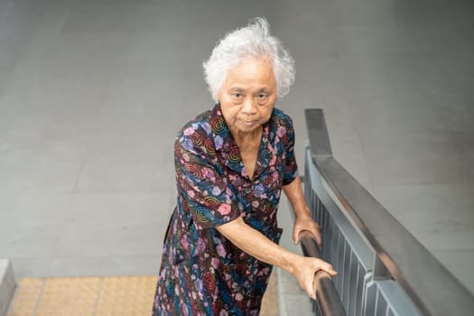 Asian senior woman patient use slope walkway handle security with help support assistant, healthy strong medical concept.