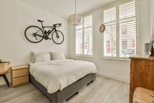 a bedroom with a bed and a bike hanging above