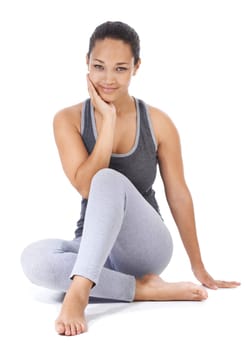 Feeling revived after her yoga session. A gorgeous young woman in gymwear sitting against a white background.