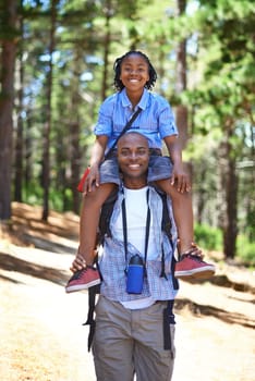 Building a love of the outdoors together. Happy african father and son spending time in the woods together.
