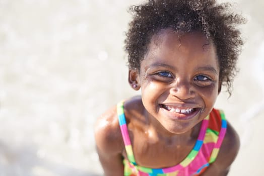 Sweet and innocent smile. A cute little african girl in a swimsuit smiling at the camera.
