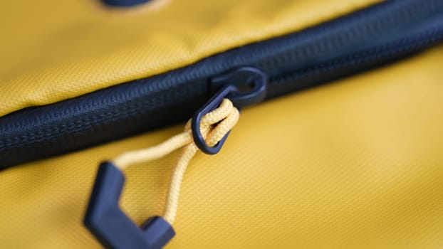 Black lock on yellow fabric backpack closeup