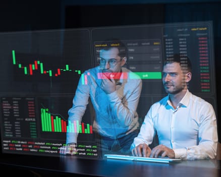 Caucasian man consulting a bearded man about stock charts on a virtual screen. HUD menu.