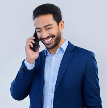 Smile, phone call and asian businessman in studio, talking and networking on white background. Smartphone, conversation and man in suit, communication and technology for investor trading at startup