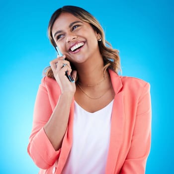 Phone call, talking and smile of business woman in conversation, chatting or communication in studio isolated on blue background. Cellphone, thinking or happy Indian female professional in discussion.