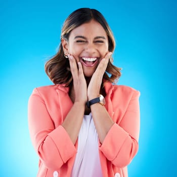 Happy, excited and portrait of woman in studio with surprise, good news and happiness expression. Wow, emoji reaction and face of Indian girl for success, celebration and smile on blue background.