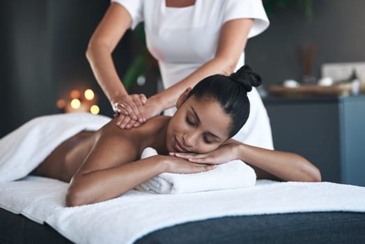 Had a tough week Then head to the spa. a young woman getting a back massage at a spa.