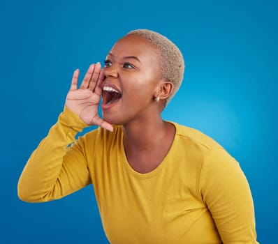 Shouting, announcement and loud with a black woman on a blue background in studio for news or communication. Hand, screaming and message with an attractive young female yelling to alert danger