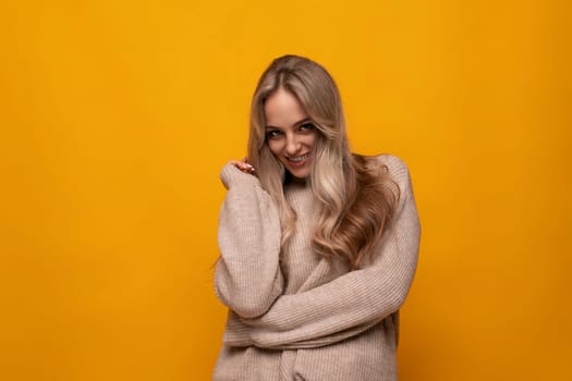 photo of shy blonde girl on yellow background