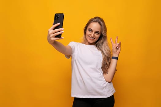a girl with a gadget in her hands is broadcasting on a yellow background
