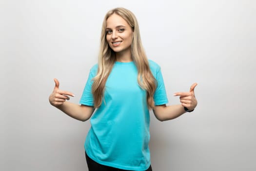 young woman shows her hands on a T-shirt on a white background