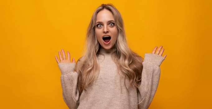 pleasantly surprised young woman over isolated yellow background